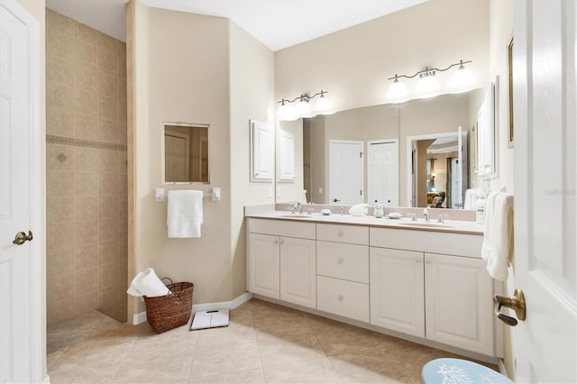 bathroom featuring tile patterned flooring, walk in shower, a sink, and double vanity