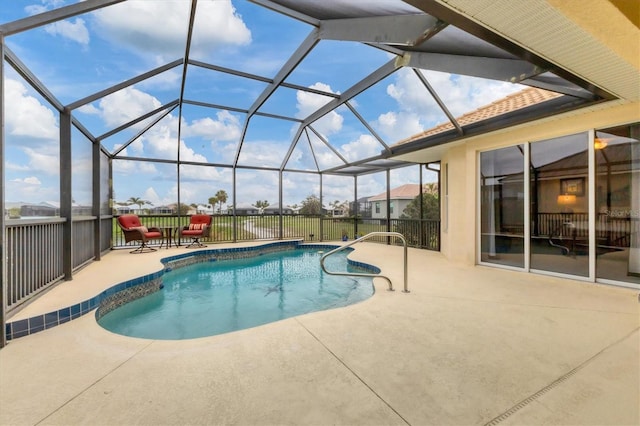 outdoor pool featuring glass enclosure and a patio