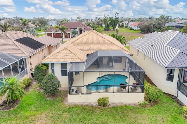 rear view of property with a fenced in pool, a residential view, glass enclosure, and stucco siding