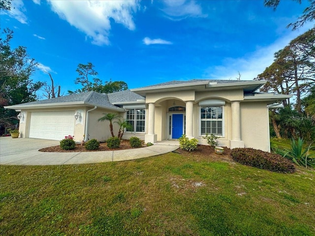 view of front of property featuring a front lawn, concrete driveway, and stucco siding