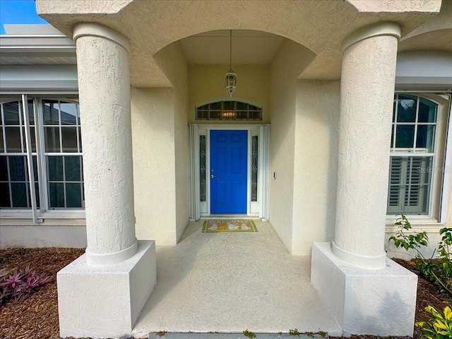 doorway to property featuring stucco siding