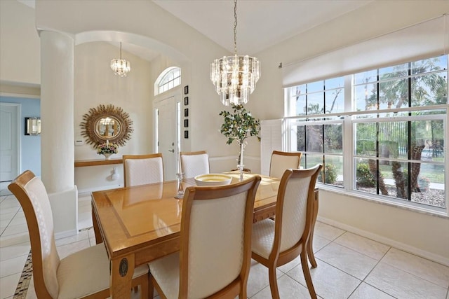 dining space with arched walkways, light tile patterned floors, vaulted ceiling, a chandelier, and baseboards