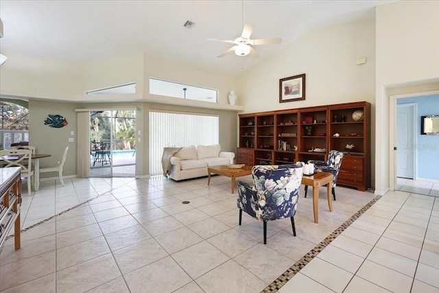 living area with light tile patterned floors, visible vents, high vaulted ceiling, and ceiling fan