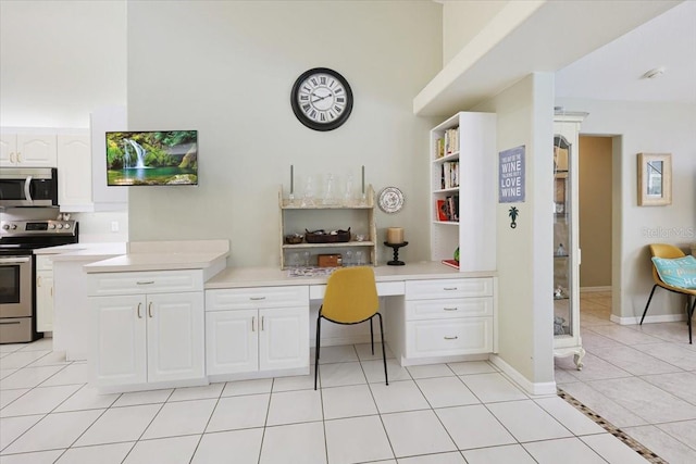 office area featuring light tile patterned floors, baseboards, and built in desk