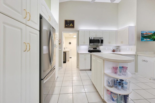 kitchen featuring light tile patterned floors, a towering ceiling, appliances with stainless steel finishes, light countertops, and open shelves