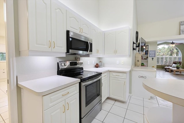 kitchen featuring stainless steel appliances, light countertops, a ceiling fan, white cabinetry, and light tile patterned flooring