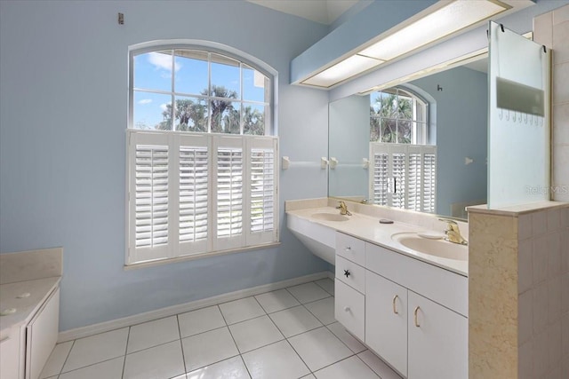 full bath with a healthy amount of sunlight, a sink, and baseboards