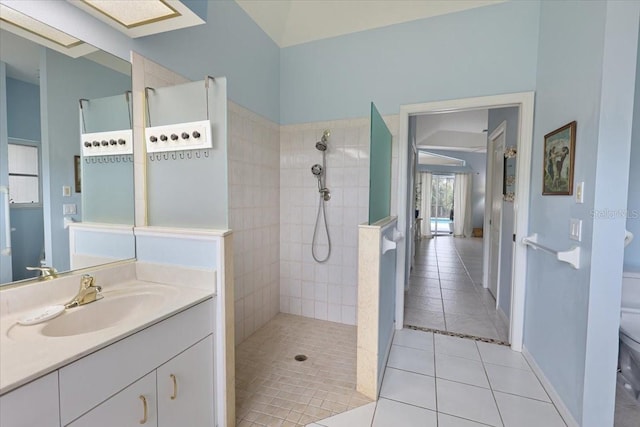 bathroom with toilet, vanity, baseboards, tile patterned floors, and walk in shower