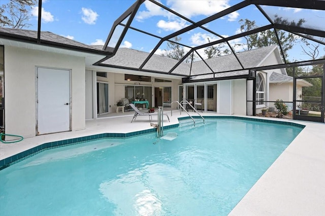 pool featuring glass enclosure, a ceiling fan, and a patio