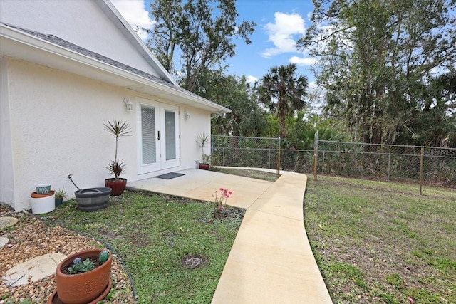 view of yard with french doors and fence