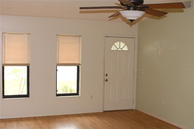 entryway with light wood finished floors, baseboards, visible vents, and a ceiling fan