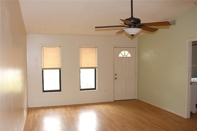 foyer with light wood-style floors, baseboards, visible vents, and a ceiling fan