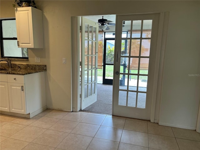 doorway featuring a sink, a ceiling fan, french doors, and light tile patterned flooring