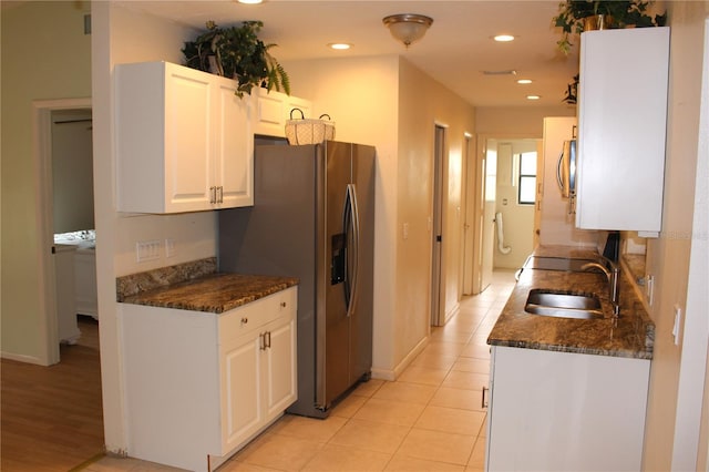 kitchen with dark stone counters, appliances with stainless steel finishes, white cabinetry, a sink, and recessed lighting