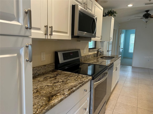 kitchen with visible vents, white cabinetry, stainless steel appliances, and dark stone countertops