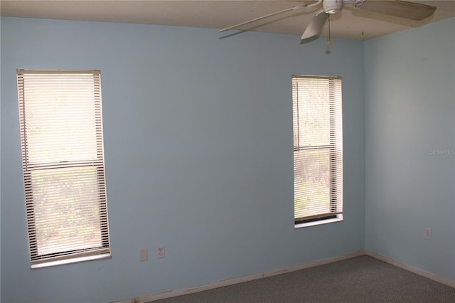 carpeted empty room featuring ceiling fan and baseboards