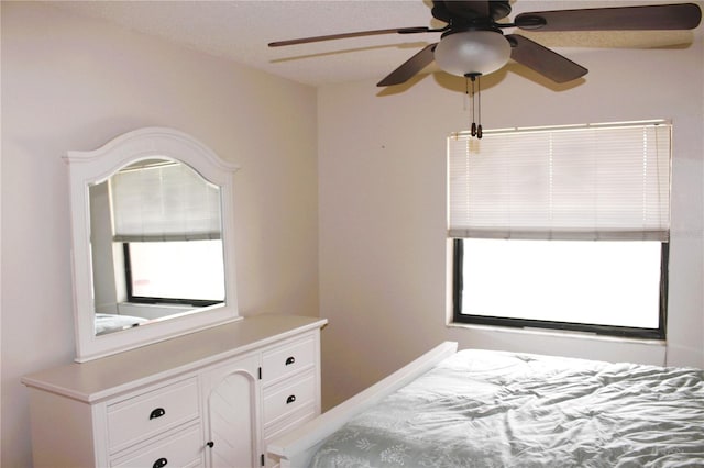 bedroom with ceiling fan and multiple windows