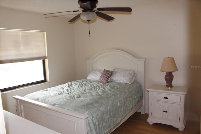 bedroom with dark wood-style flooring and a ceiling fan