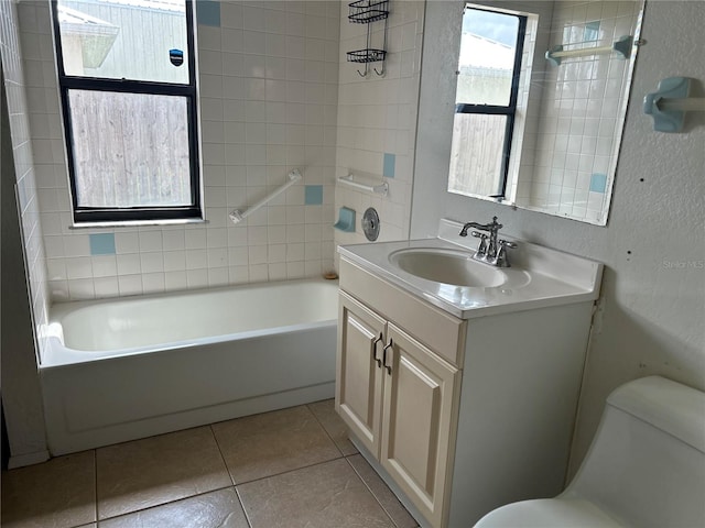 bathroom featuring a textured wall, toilet, vanity,  shower combination, and tile patterned floors