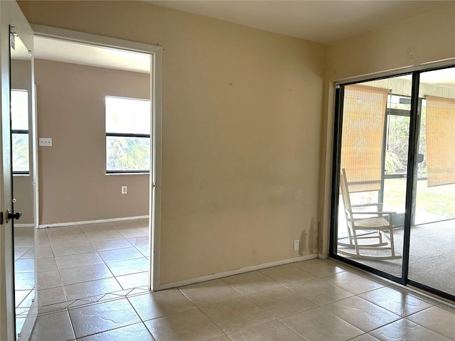 spare room with baseboards and light tile patterned flooring