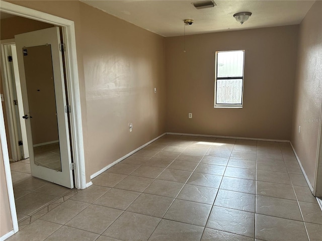 empty room with light tile patterned floors and baseboards