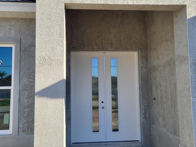 entrance to property with french doors and stucco siding