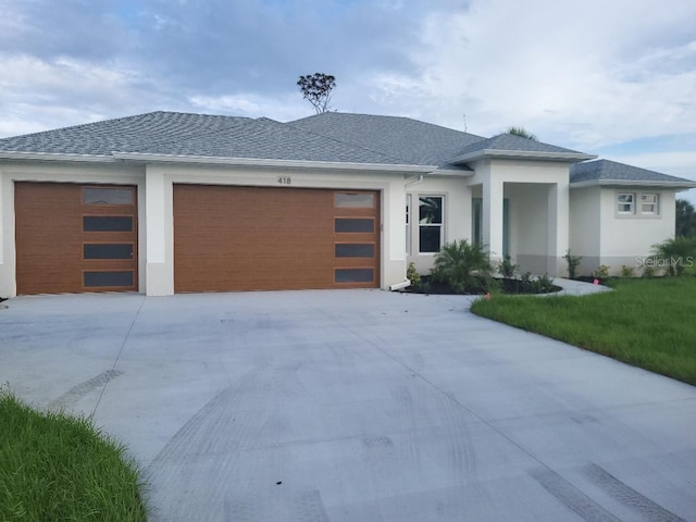 418 Rotonda Cir, Rotonda West, FL 33947 - prairie-style house featuring an attached garage, driveway, a front lawn, and stucco siding