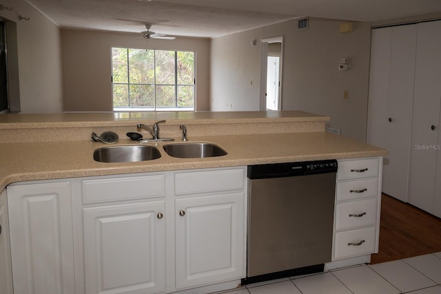 kitchen featuring light countertops, white cabinetry, a sink, and stainless steel dishwasher