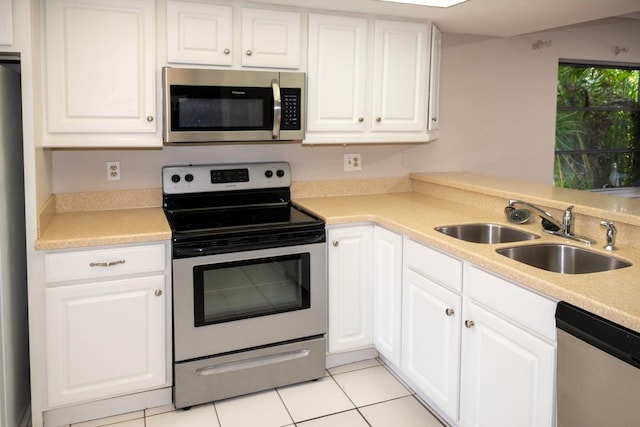 kitchen featuring appliances with stainless steel finishes, a sink, and white cabinetry