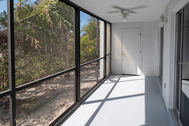 unfurnished sunroom featuring a ceiling fan