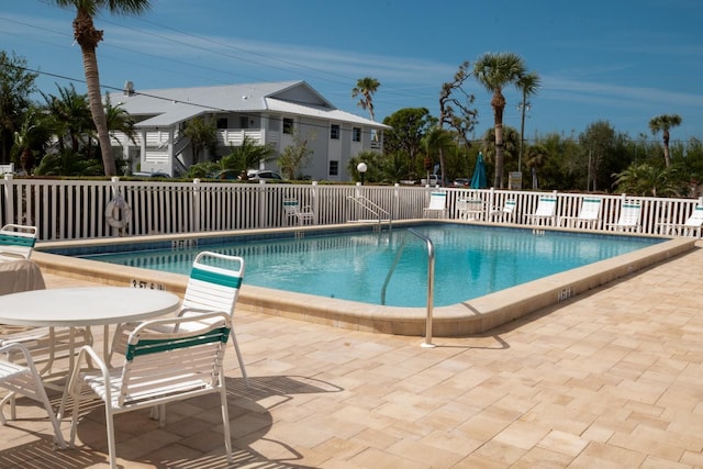 community pool featuring a patio area and fence