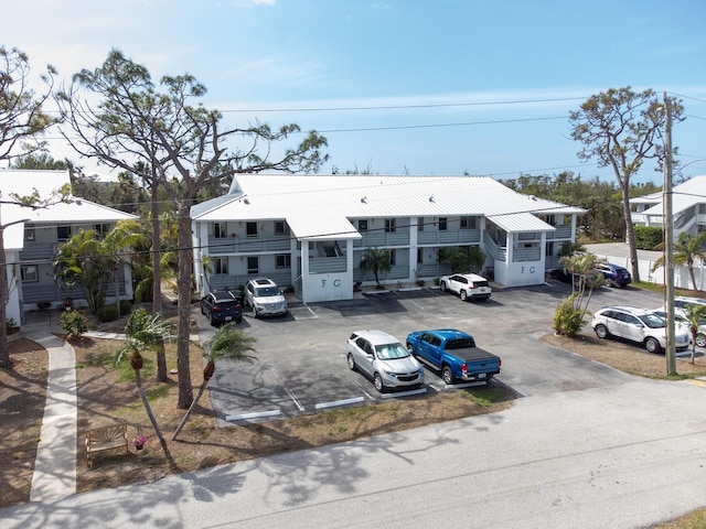 view of front facade featuring uncovered parking and metal roof