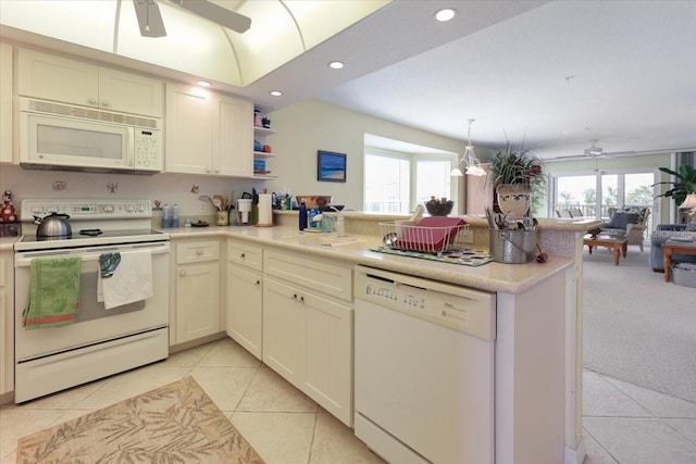 kitchen featuring white appliances, open floor plan, a peninsula, a sink, and a wealth of natural light