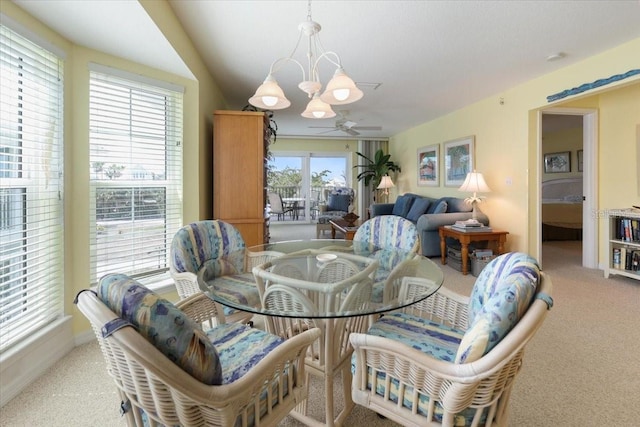 dining room featuring carpet and ceiling fan with notable chandelier