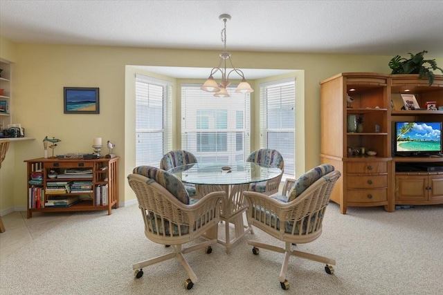 dining room featuring light carpet, baseboards, and a textured ceiling