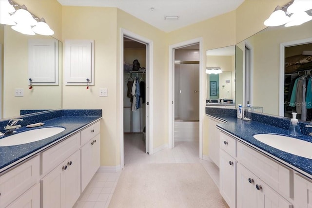 bathroom featuring two vanities, a sink, and tile patterned floors