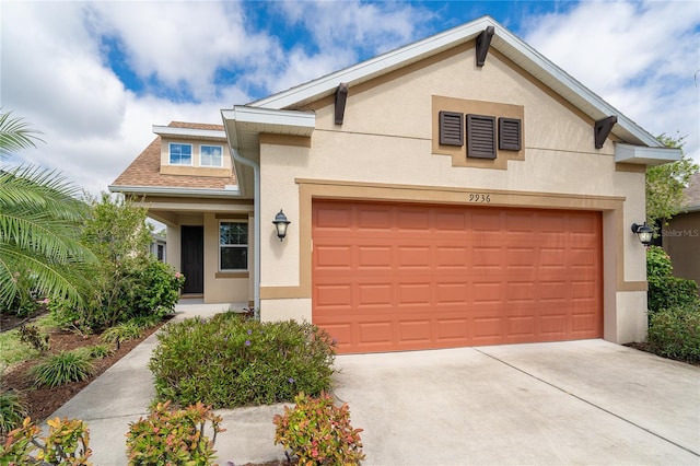 view of front of home with a garage, driveway, and stucco siding