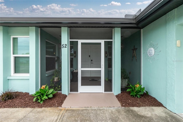 entrance to property featuring stucco siding