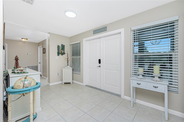 foyer entrance featuring light tile patterned floors, visible vents, and baseboards