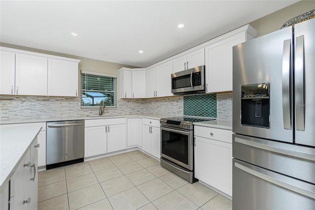 kitchen featuring light tile patterned floors, decorative backsplash, stainless steel appliances, light countertops, and a sink