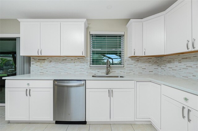 kitchen featuring light countertops, a sink, backsplash, and stainless steel dishwasher