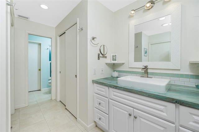 full bath with toilet, vanity, visible vents, tile patterned floors, and tasteful backsplash