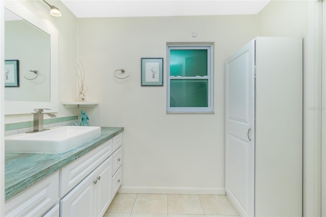 bathroom featuring backsplash, tile patterned flooring, vanity, and baseboards