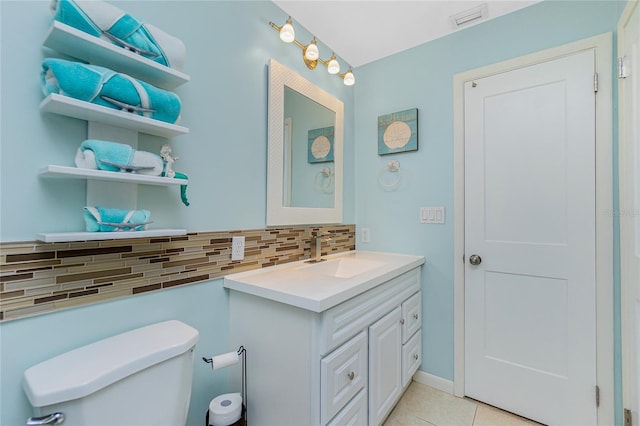 bathroom with tasteful backsplash, visible vents, toilet, vanity, and tile patterned flooring