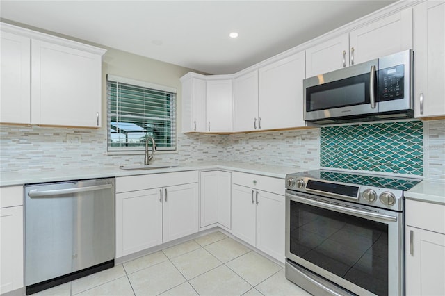 kitchen featuring light tile patterned floors, a sink, white cabinetry, light countertops, and appliances with stainless steel finishes