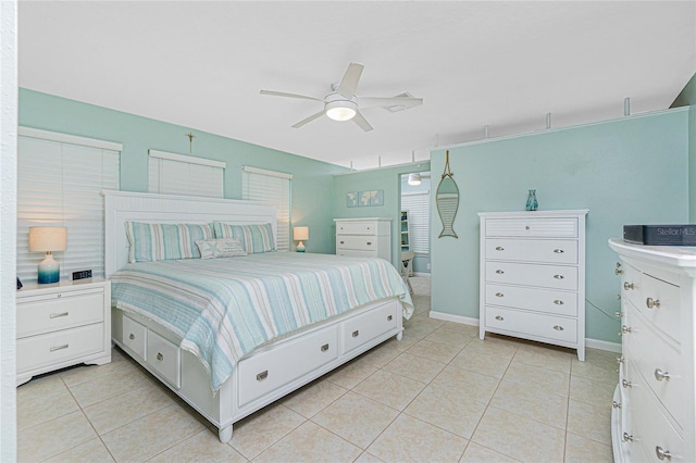 bedroom with light tile patterned flooring, ceiling fan, and baseboards