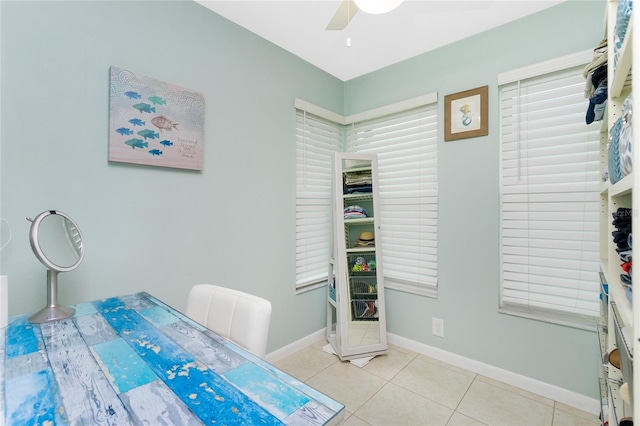 interior space featuring light tile patterned floors, ceiling fan, and baseboards