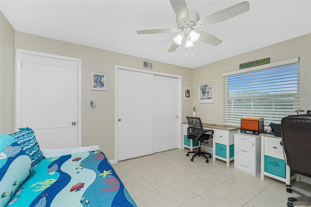 bedroom featuring a closet, visible vents, ceiling fan, and light tile patterned floors