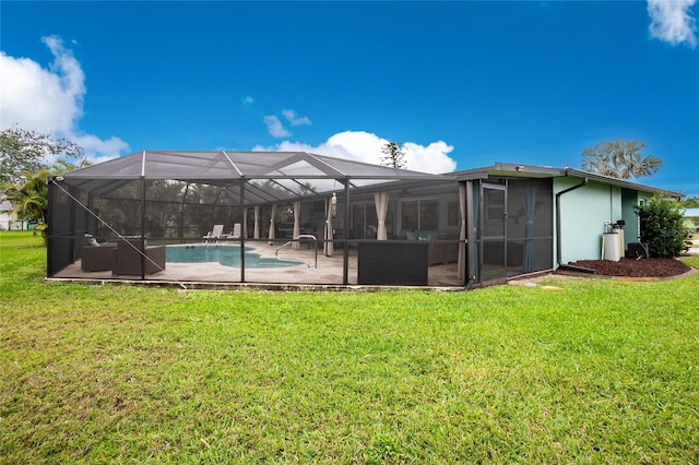 back of house with a lanai, an outdoor pool, a lawn, and a patio