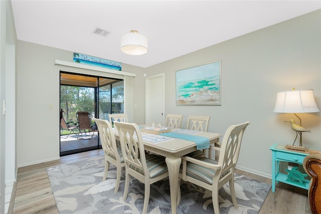 dining space with visible vents, light wood-style flooring, and baseboards